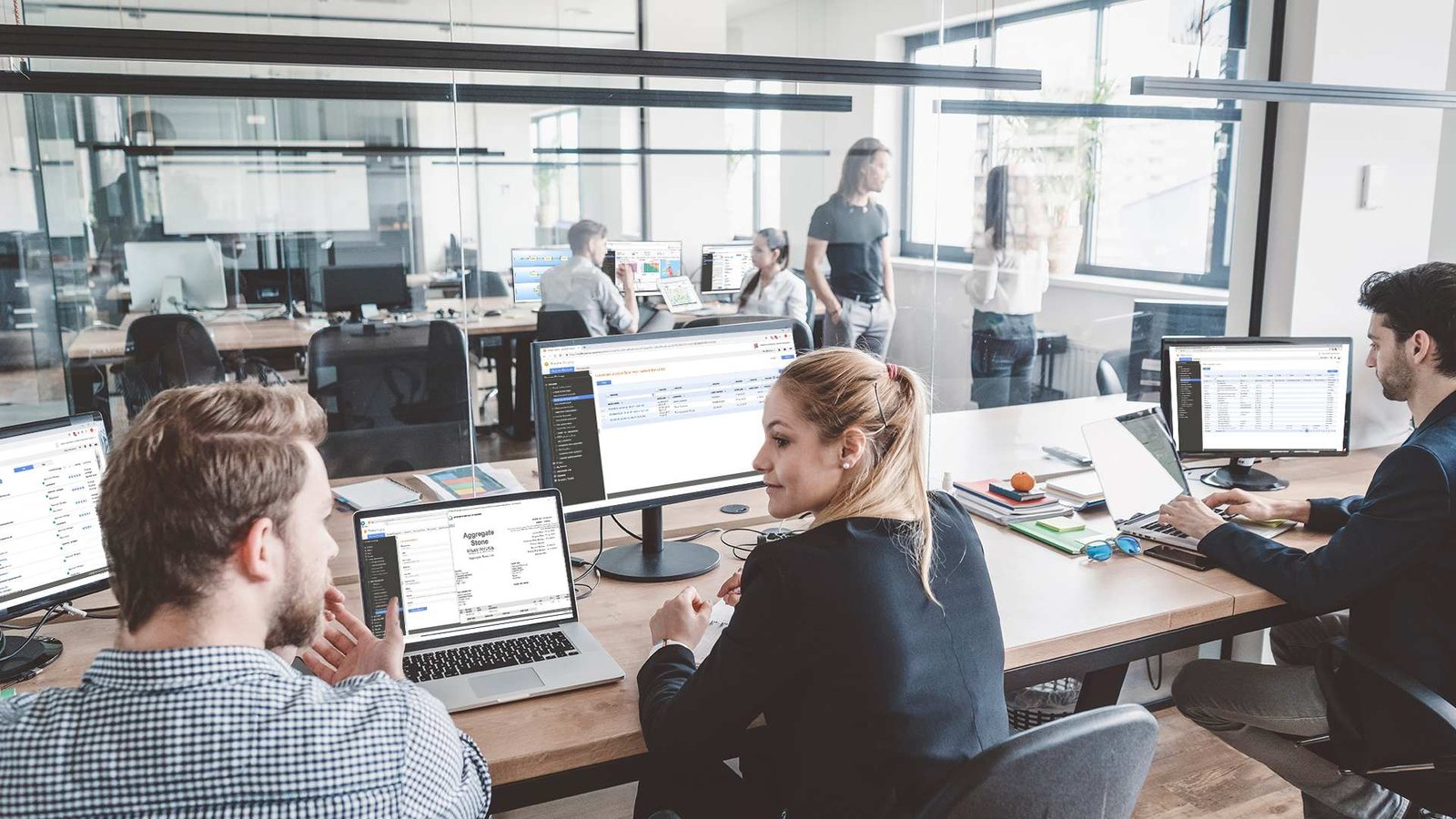 Team in office on computers with invoices